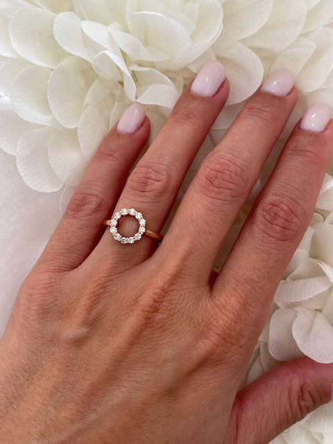 Hand wearing a diamond ring with a white floral background